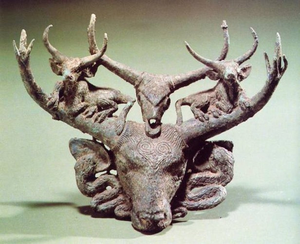 Đầu một con bò đực được trang trí với hai con rắn, hai con bò nhỏ và một họp sọ bò.