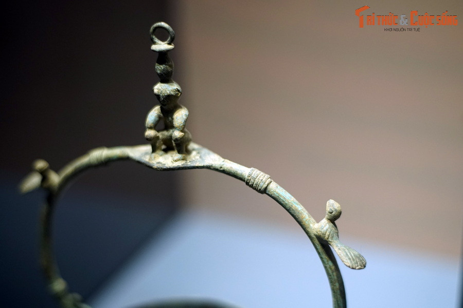 Cận cảnh hình người và chim trên quai đèn.