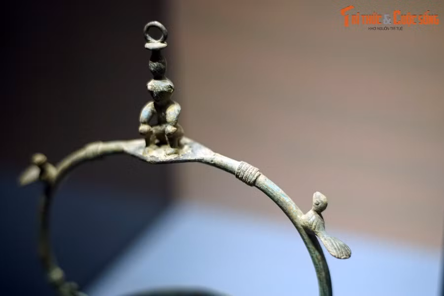 Cận cảnh hình người và chim trên quai đèn.