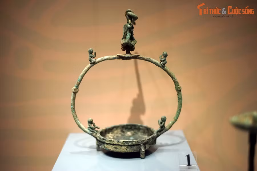 Đèn treo bằng đồng có quai trang trí hình người quỳ, người chơi nhạc cụ và chim công, thế kỷ 2-1 TCN.