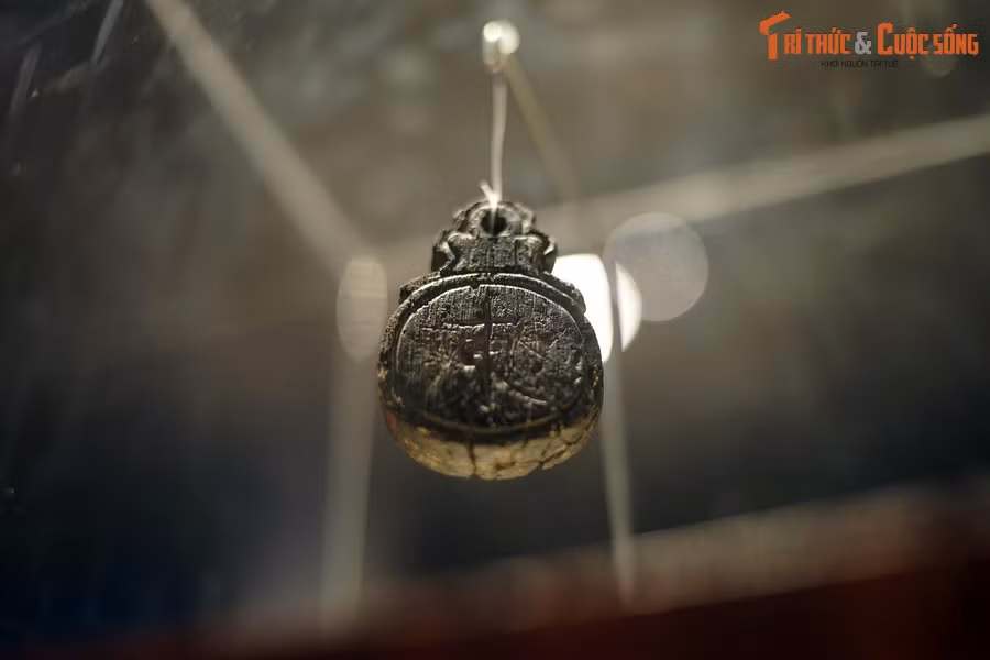 Hiện vật có chiều dài 6 cm, rộng 3 cm, được làm bằng gỗ lim, màu đen, hình oval, phía trên có tai như tai khánh.