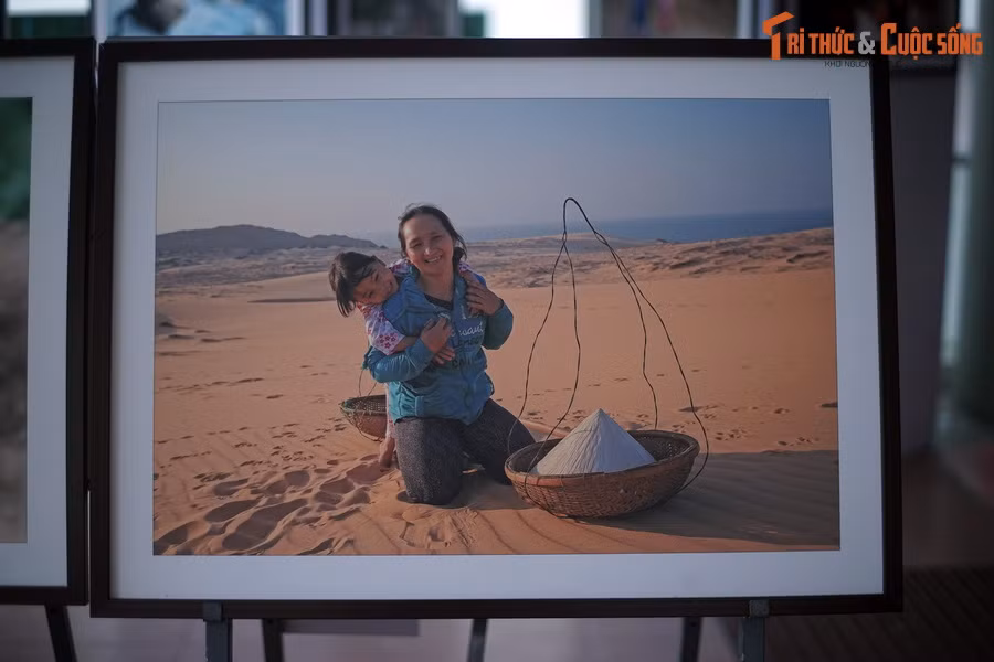  Trên cồn cát: Hai mẹ con ngồi chờ khách thuê làm mẫu chụp ảnh tại đồi cát Phan Thiết, tỉnh Bình Thuận.