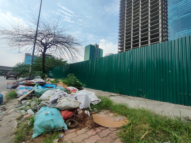 Rác thải cũng như cây cối bao phủ hết phần vỉa hè quanh dự án, không còn lối đi bộ nào.