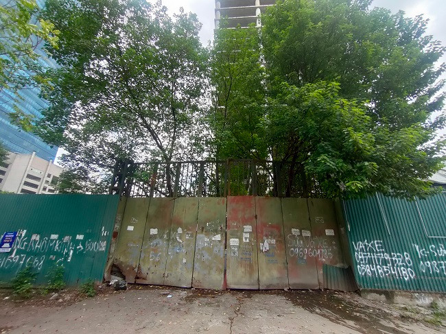 Cổng chính vào dự án Vicem Tower trên mặt đường Phạm Hùng luôn trong tình trạng "cửa đóng then cài", cây cỏ mọc um tùm sau nhiều năm bỏ hoang. 