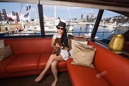 Một quý cô thuộc giới thượng lưu Trung Quốc ôm chó cưng ngồi trên chiếc du thuyền sang trọng trong một sự kiện dành riêng cho nhà giàu Trung Quốc ở thành phố Đại Liên.