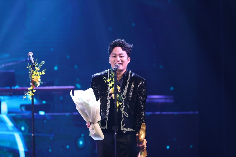 Ở Cống hiến 2025, Tùng Dương được đề cử ở 4 hạng mục gồm Album của năm (Multiverse - Đa vũ trụ), Chương trình của năm (Người đàn ông hát), Bài hát của năm (Tái sinh) và Nam ca sĩ của năm. Kết quả, Tùng Dương nhận giải Bài hát của năm, giữ vững “ngôi vương” của mình trên “bảng tổng sắp” cúp Cống hiến mà nam ca sĩ đã giành được với 14 lần. Ảnh: BTC.