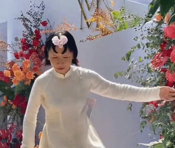 Cụ thể, bên cạnh dàn phù dâu toàn mỹ nhân diện áo dài trắng nền nã thì "hiện tượng mạng" Trang Hý lại có tạo hình được cho là lạc quẻ khi làm kiểu tóc hình trái tim, đính một bông hoa giữa trán làm điểm nhấn.