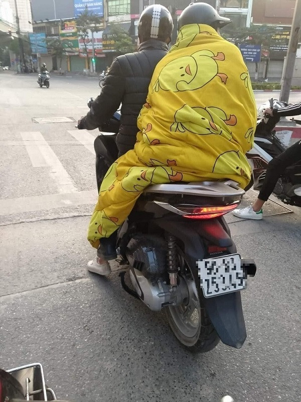 Thêm một người ngồi sau cũng quấn chăn giữ ấm. Ảnh: Chính Vũ