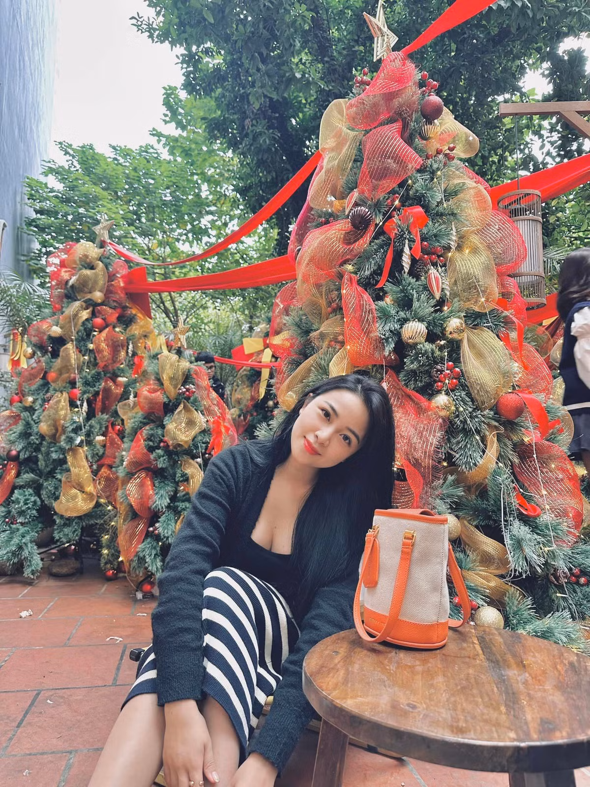 Cô nàng tạo dáng bên cây thông được trang trí rực rỡ.