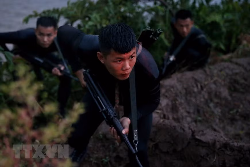 Đặc công nước với súng trường tấn công AK báng gấp cùng bộ đồ lặn trên người bí mật tiếp cận mục tiêu giả định. Nguồn ảnh: TTXVN.