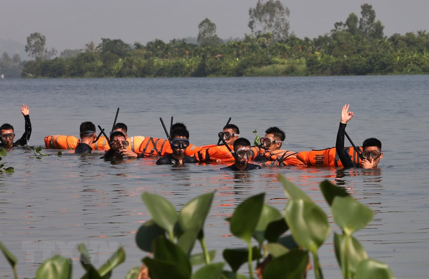 Đặc công nước huấn luyện bơi qua sông tiếp cận mục tiêu, trang bị của những chiến sĩ chỉ đơn giản là kính lặn, ống thông khí và một chiếc áo phao buộc vào chân để đảm bảo an toàn. Nguồn ảnh: TTXVN.