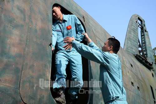 Đội trưởng Đội TKCN đường không 2 hướng dẫn tỉ mỉ tư thế, động tác ra máy bay cho một nhân viên dù.