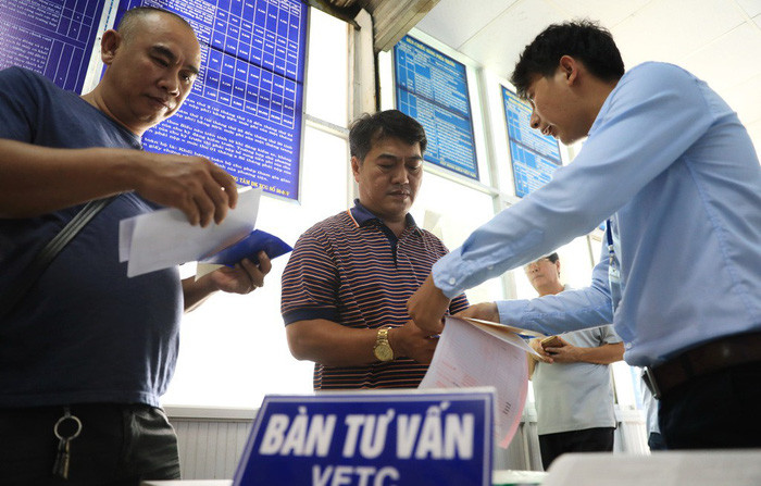 Người dân làm thủ tục đăng ký dán tem thu phí tự động VETC tại trung tâm đăng kiểm xe cơ giới ở TP.HCM - Ảnh: HỮU KHOA Người dân làm thủ tục đăng ký dán tem thu phí tự động VETC tại trung tâm đăng kiểm xe cơ giới ở TP.HCM - Ảnh: HỮU KHOA