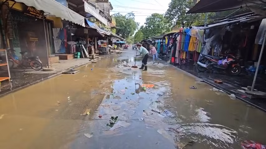 Nước rút dần, người dân Hội An tranh thủ dọn rác và bùn non.