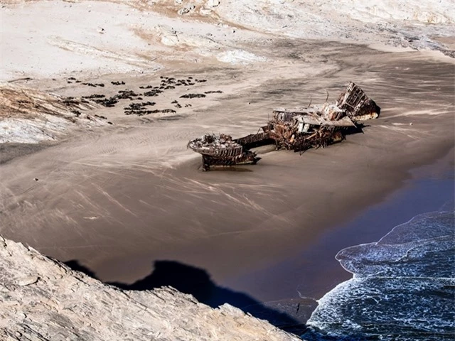 1. Skeleton Coast tại Namibia Đây là vùng đất bí ẩn nhất của Namibia, cũng là địa điểm được cảnh báo không nên đến du lịch hay thám hiểm. Nơi đây có vùng sa mạc khắc nghiệt ở phía Bắc, cảnh quan vô cùng rùng rợn với xác hàng nghìn con tàu bị đắm dạt vào. Số lượng tàu đắm dạt vào bờ cát Skeleton Coast được cho biết là không thể thống kê nổi vì quá nhiều. Sự hoang tàn, hiu quạnh đó vẫn chưa là gì bởi khu vực này còn có những loài thú dữ rất nguy hiểm. Sư tử, báo, linh cẩu, chó rừng… luôn chực chờ và có thể tấn công bất cứ ai đặt chân đến đây.