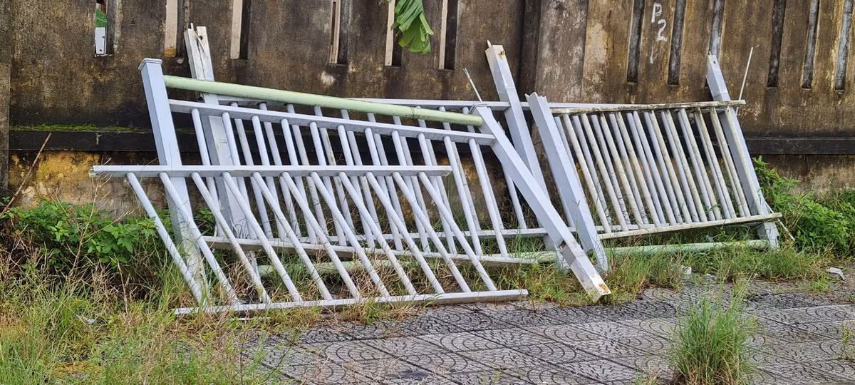 Sụt lún khiến hàng rào sắt dọc bờ kênh thoát nước gãy đổ, được mang sang phía bên vỉa hè sát Trường Tiểu học Lê Văn Tám.