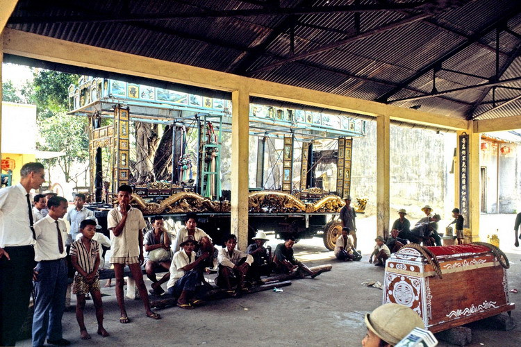 Những người khiêng quan tài và cỗ xe tang được trang trí cầu kỳ.