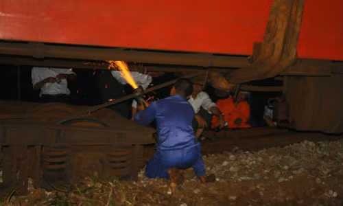 Hiện trường nửa đêm qua, công nhân dùng máy cắt để cắt bỏ những bộ phận bị hỏng của các toa tàu bị lật để cần cẩu có thể dễ dàng đưa chúng trở lại đường ray.