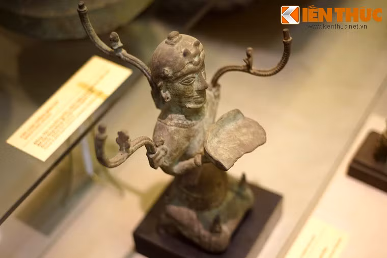 Có nhiều cách lý giải khác nhau về tạo hình của hiện vật này. Theo nhà nghiên cứu O.Jane, bức tượng thể hiện hình ảnh một vị thần. Ý kiến khác cho rằng cây đèn thể hiện văn hóa Hán và người đàn ông quỳ là một tù binh Hung Nô bị bắt và trở thành người hầu bê đèn. Theo quan điểm này, cây đèn hình người quỳ là hiện vật của sự tiếp biến văn hóa Việt- Hán.