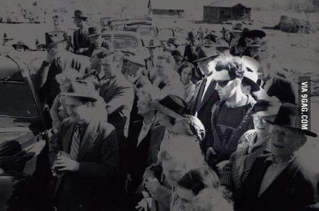 Trong bức ảnh, người đàn ông đeo kính râm khác biệt với mọi người xung quanh. Trang phục của người này có phần hiện đại hơn so với quần áo thường ngày của dân Âu - Mỹ thời đó.