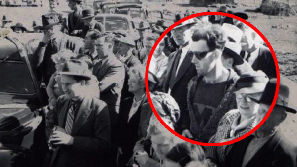 Cụ thể, người này mặc áo phông bên trong, áo khoác có khóa kéo ở ngoài. Trên tay người này dường như cầm một chiếc máy ảnh nhỏ.