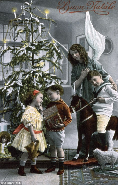 Trẻ em vui vẻ khi bóc quà Giáng sinh tại cây thông Noel.