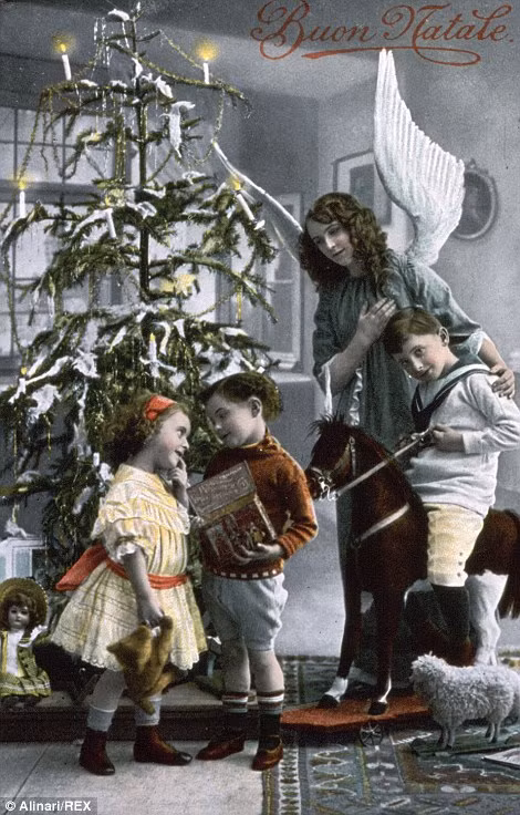 Trẻ em vui vẻ khi bóc quà Giáng sinh tại cây thông Noel.