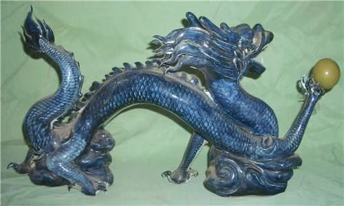 Vì vậy, ông lão tỉ mỉ lau sạch bụi bẩn bám trên cổ vật hình rồng màu xanh. Ông nhận thấy món đồ cổ này là đồ gốm sứ. Một móng vuốt của con rồng cầm một hạt ngọc màu vàng.