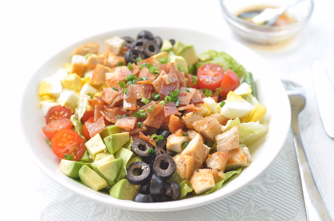 Cobb salad phổ biến tại Mỹ là sự tổng hợp của rất nhiều nguyên liệu như rau xanh sống, cà chua, quả bơ, gà, trứng, ba chỉ xông khói, hành lá.