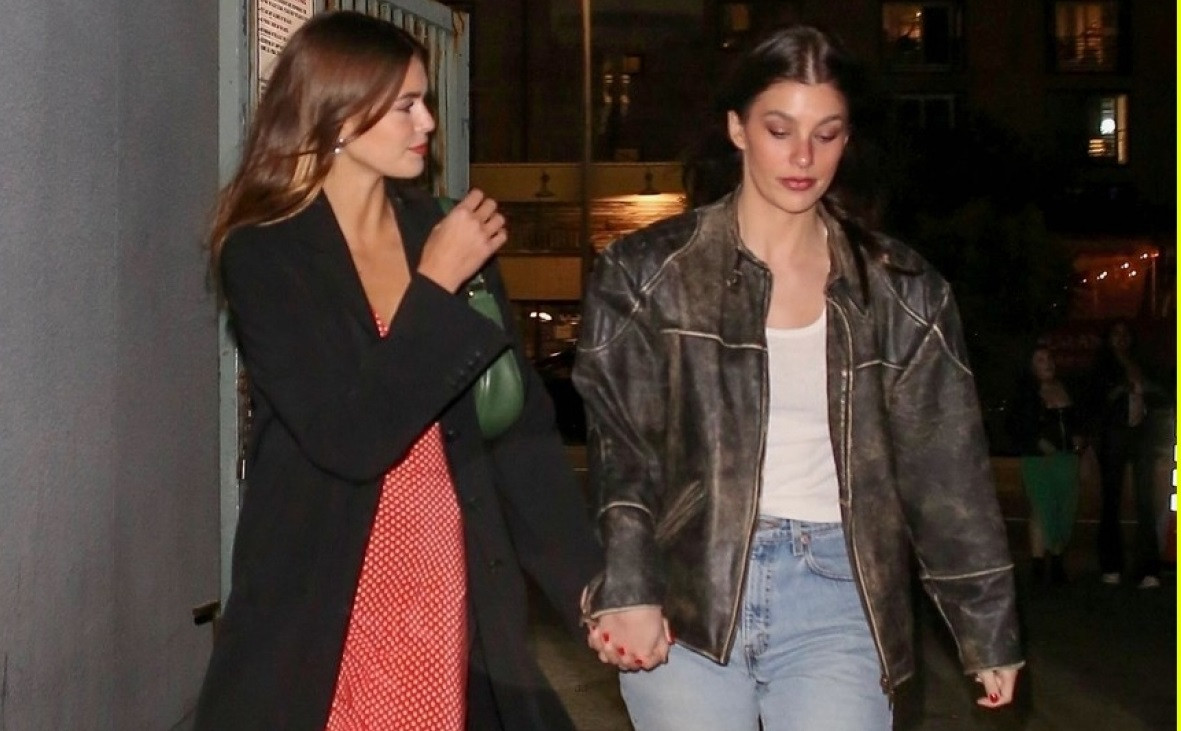 Kaia Gerber và bạn thân nắm tay đi dạo trên phố lúc về đêm.