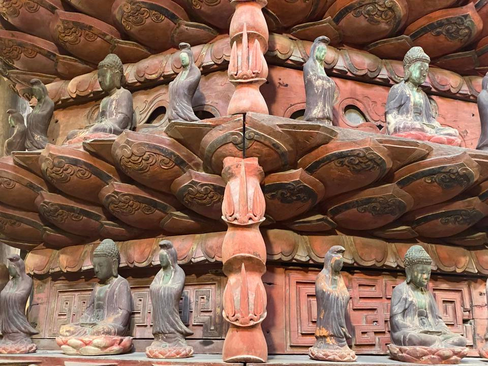 Tòa Cửu phẩm Liên Hoa có 6 mặt, mỗi mặt rộng 1,2m. Để hoàn thành Bảo vật Quốc gia này, các nghệ nhân thời xưa dựng cột trụ lim ở giữa, 6 cột chạm khắc hình trúc hóa rồng ở chung quanh. Liên kết trụ giữa với các cột rồng bằng một hệ thống xà gánh đan chéo. Ảnh: Kinh tế &amp; Đô thị.