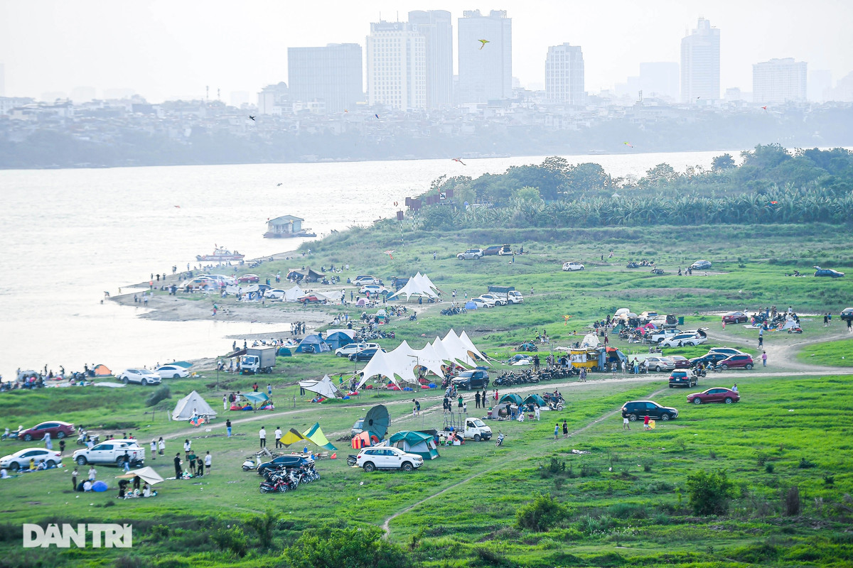 Những ngày nghỉ lễ, thời tiết Hà Nội có nắng nhẹ, không khí mát mẻ. Nhiệt độ dao động 22 - 31 độ C, rất thích hợp để dã ngoại. Bãi đất ven sông Hồng (phía chân cầu Vĩnh Tuy) vẫn là điểm vui chơi được nhiều người dân Thủ đô lựa chọn. Thay vì đi du lịch, các gia đình ở Hà Nội lái ô tô ra ngoại thành "đổi gió", cắm trại, nướng thịt tận hưởng kỳ nghỉ bên người thân. Theo ghi nhận của Pv Dân trí , các bãi cỏ ven sông Hồng chật kín ô tô, lều trại.