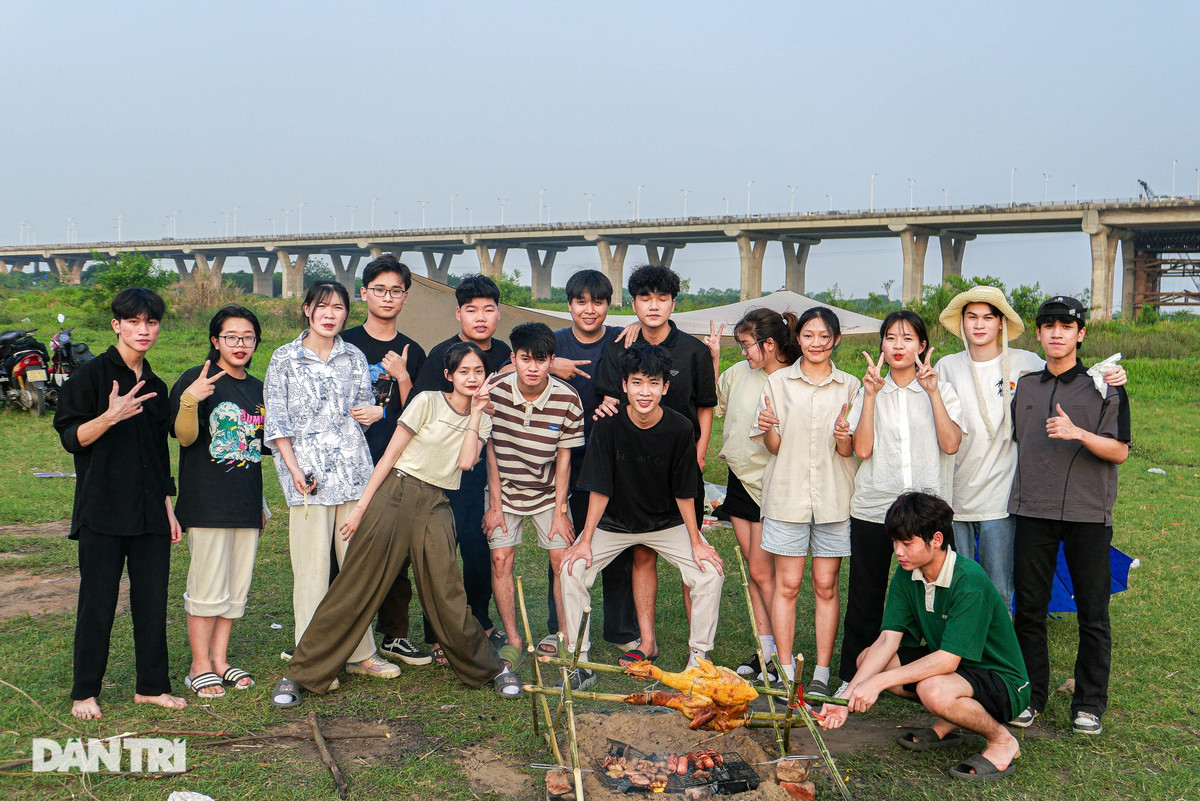Nhóm bạn trẻ di chuyển gần 20km từ huyện Văn Giang, Hưng Yên tới đây để cắm trại dã ngoại. "Mình cùng bạn bè chuẩn bị đồ ăn từ sáng, chiều cả nhóm di chuyển tới bãi giữa ven sông Hồng đoạn chân cầu Vĩnh Tuy. Ở đây rất thoáng có gió mát phù hợp với việc cắm trại vui chơi", một bạn trong nhóm chia sẻ.