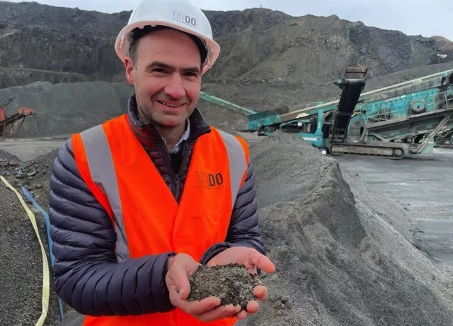 Giữa âm thanh ồn ào của những máy móc hạng nặng hoạt động tại một mỏ đá, ông Jim Mann cúi xuống và nhặt những hòn đá nhỏ màu đen. Ông nói rằng đó là "bụi ma thuật". Trên thực tế, đây là những mẩu đá bazan.