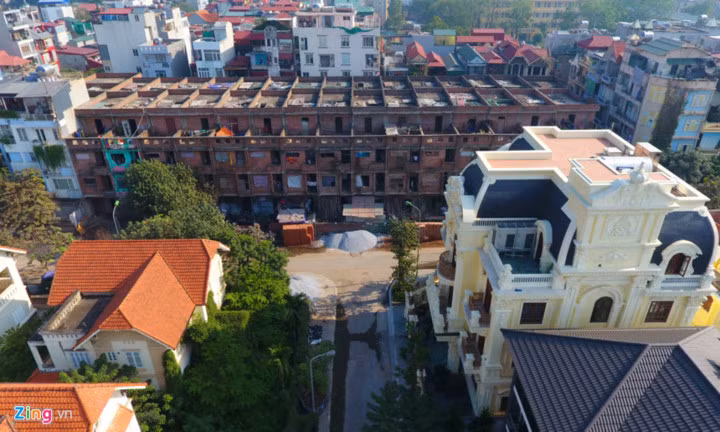 Dãy nhà "mất mỹ quan" lọt thỏm trong khu biệt thự triệu đô (phía trước), xung quanh là, khu dân cư văn hóa cùng những ngôi nhà cao tầng hiện đại. Không những vậy, vài năm nay, ở đây xảy ra tình trạng mất an ninh trật tự, đặc biệt dịch sốt xuất huyết tiềm ẩn nguy cơ bùng phát... (Ảnh: Zing).