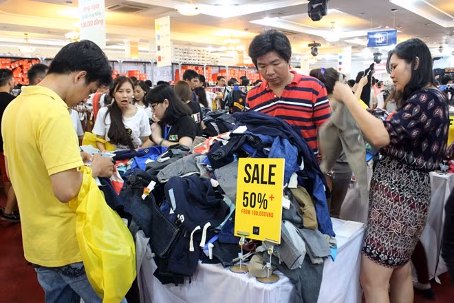 Đồ thời trang hàng hiệu giảm giá 50% được chất thành từng đống cho khách lựa chọn. Chị Hải Yến (quận Tân Bình, TP HCM) cho biết, sau khi giảm giá, mỗi món đồ thời trang vẫn có giá hàng triệu, chục triệu đồng. Tuy nhiên, đây là cơ hội để chị sở hữu những món đồ hàng hiệu. Chen chân từ 10h, đến tận 13h, chị mới lựa cho mình được một bộ đồ thời trang.