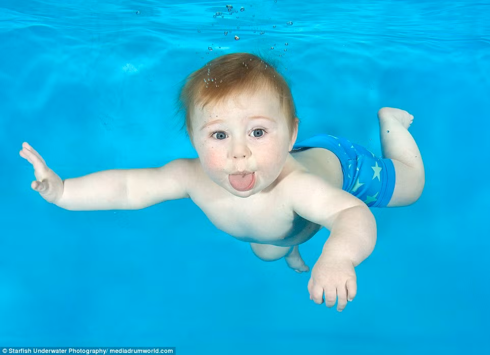 Bé Ethan 10 tháng tuổi lè lưỡi trước ống kính máy ảnh.