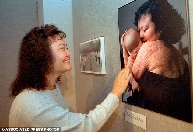 Bà Phúc đang ngắm tấm ảnh bà ôm con trai đầu lòng. Bên cạnh là bức hình nổi tiếng "Em bé Napalm".