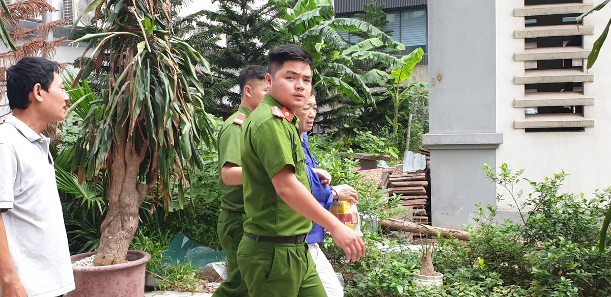 Trùm bảo kê chợ Long Biên - Hưng "kính" được 2 cảnh sát áp giải.