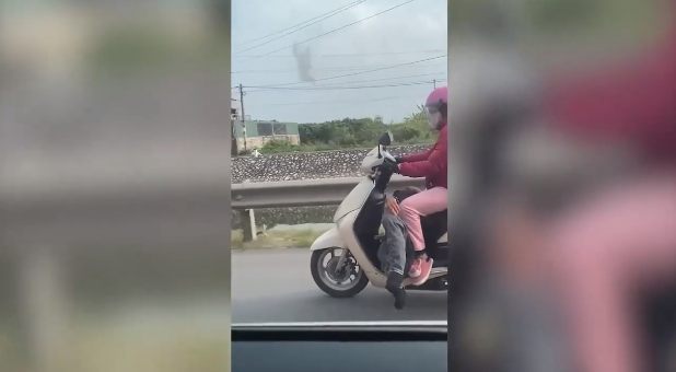 Dù chở chồng say xỉn trong tư thế khá khó như vậy, nhưng chị vợ rất chắc tay lái, điều khiển chiếc xe chạy bon bon trên đường.