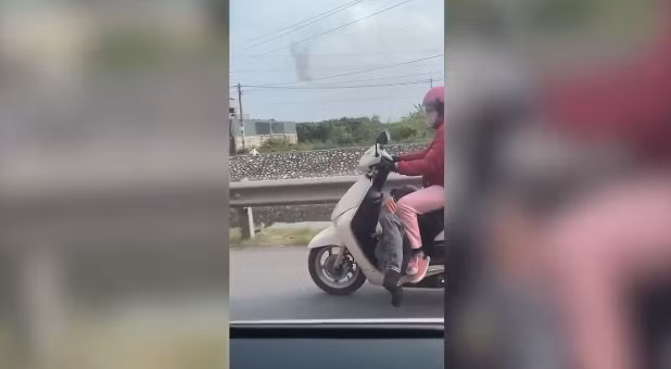 Dù chở chồng say xỉn trong tư thế khá khó như vậy, nhưng chị vợ rất chắc tay lái, điều khiển chiếc xe chạy bon bon trên đường.