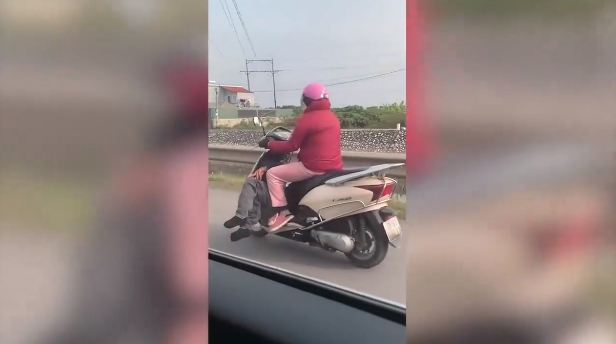 Trong đoạn clip được chia sẻ, chị vợ đi xe Lead, dưới chỗ để chân là một người đàn ông nằm ngang, được cho là chồng trong tình trạng say rượu không biết trời trăng gì.