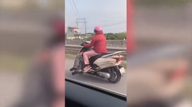 Trong đoạn clip được chia sẻ, chị vợ đi xe Lead, dưới chỗ để chân là một người đàn ông nằm ngang, được cho là chồng trong tình trạng say rượu không biết trời trăng gì.