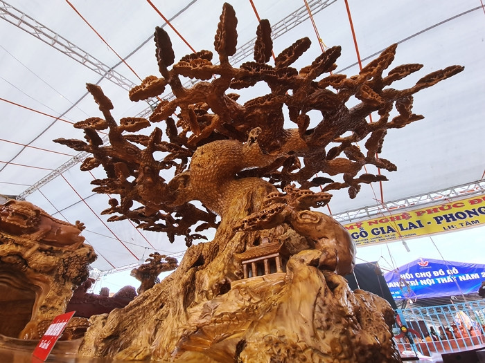 Chiếc bàn của bộ bàn ghế này được tạo hình một con rùa đang cõng trên lưng một cây tùng cao chừng 2m, tán lá cây xòe rộng ra 4 phía.