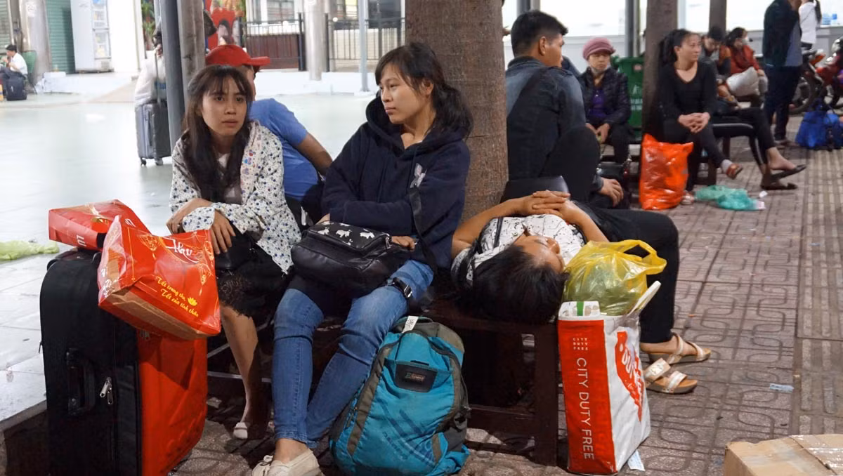Chị Lê Thúy Hiền (25 tuổi, quê Phú Yên, ngồi bên trái) cho biết, xe từ Phú Yên vào bến xe Miền Đông lúc 1h sáng và phải ngồi chờ xe buýt tuyến 95 để về nhà trọ ở khu công nghiệp Tân Bình. "Bình thường từ Phú Yên vào bến xe Miền Đông khoảng 4-5h sáng nhưng do Tết, nhà xe quay đầu để về quê đón khách nên xe chạy rất nhanh. Do vậy, mình và mọi người phải ngồi chờ xe buýt chứ đi taxi, xe ôm rất tốn kém"- lời chị Hiền.