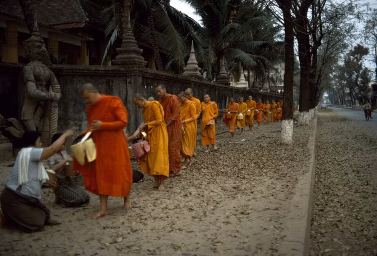 Các nhà sư nhận bố thí từ người dân bên ngoài một ngôi chùa ở Vientiane. Ảnh: Hiroji Kubota/ Magnum Photos.