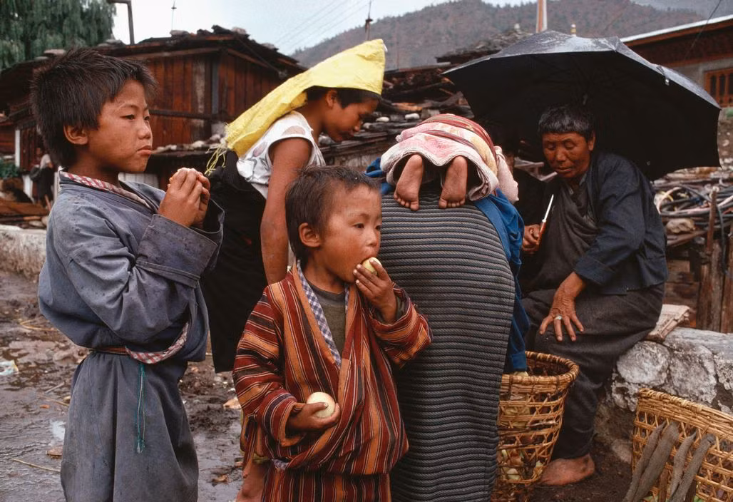 Phụ nữ và trẻ em ở quầy hoa quả bên đường. Ảnh: Martin Parr/ Magnum Photos.
