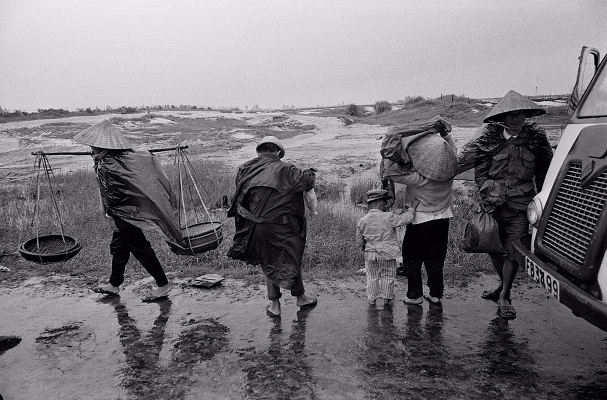 Người dân chờ chuyến xe khách rời Quảng Trị khởi hành trong cơn mưa mùa hạ. Ảnh: A. Abbas.