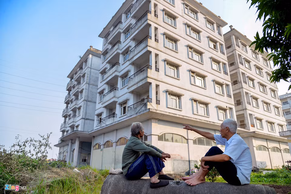 Hai ông cụ nhìn về phía tòa nhà không khỏi xót xa, tiếc nuối và cho rằng nhiều người nhà không có để ở, còn chung cư thì bỏ hoang một cách lãng phí. Ảnh: Zing.