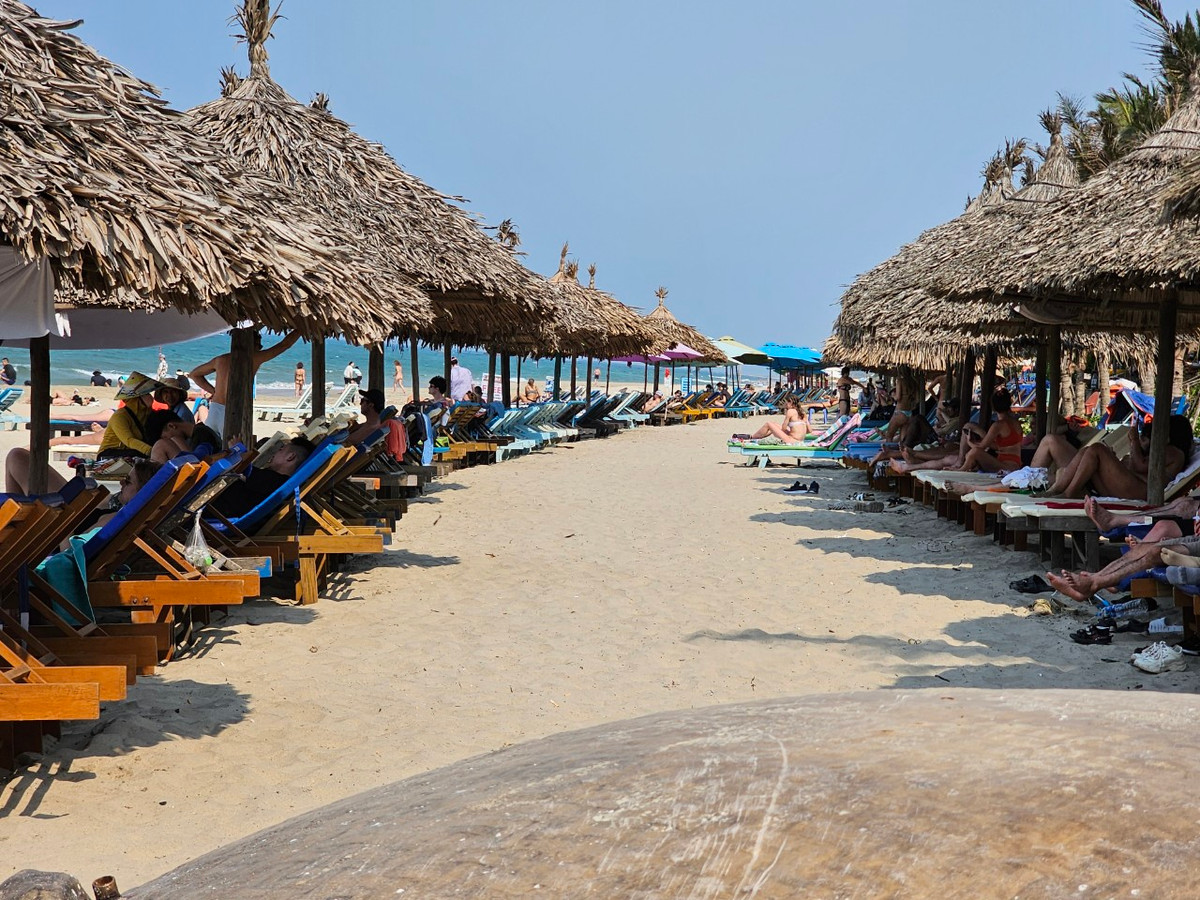 Các ghế dài đặt dưới mái tranh trên bãi biển An Bàng kín du khách nước ngoài lúc 14h ngày 30/4.